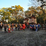 笑顔で綱を体に巻いた人が歩いています。酔っぱらっておかしくなったわけではありません。