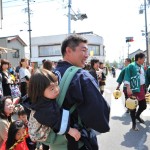 ええええ!!!!?初めて見ました。子供背負って、交通整理している人!でも、これには深い事情があるのです。ここのお兄ちゃんが獅子舞で名誉な役をやるので、家族みんなが大忙しなのです。頼もしいお父さんの姿を見て、つくづくいい人に見えます。